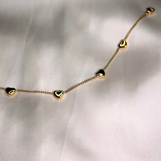 Armbånd med små gullhjerter, nærbilde