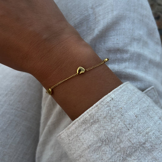Armbånd med gullhjerter på håndledd