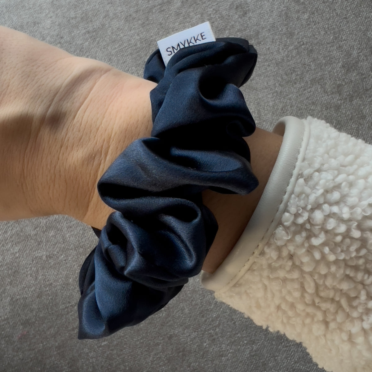 Scrunchie i silke på håndledd, marineblå